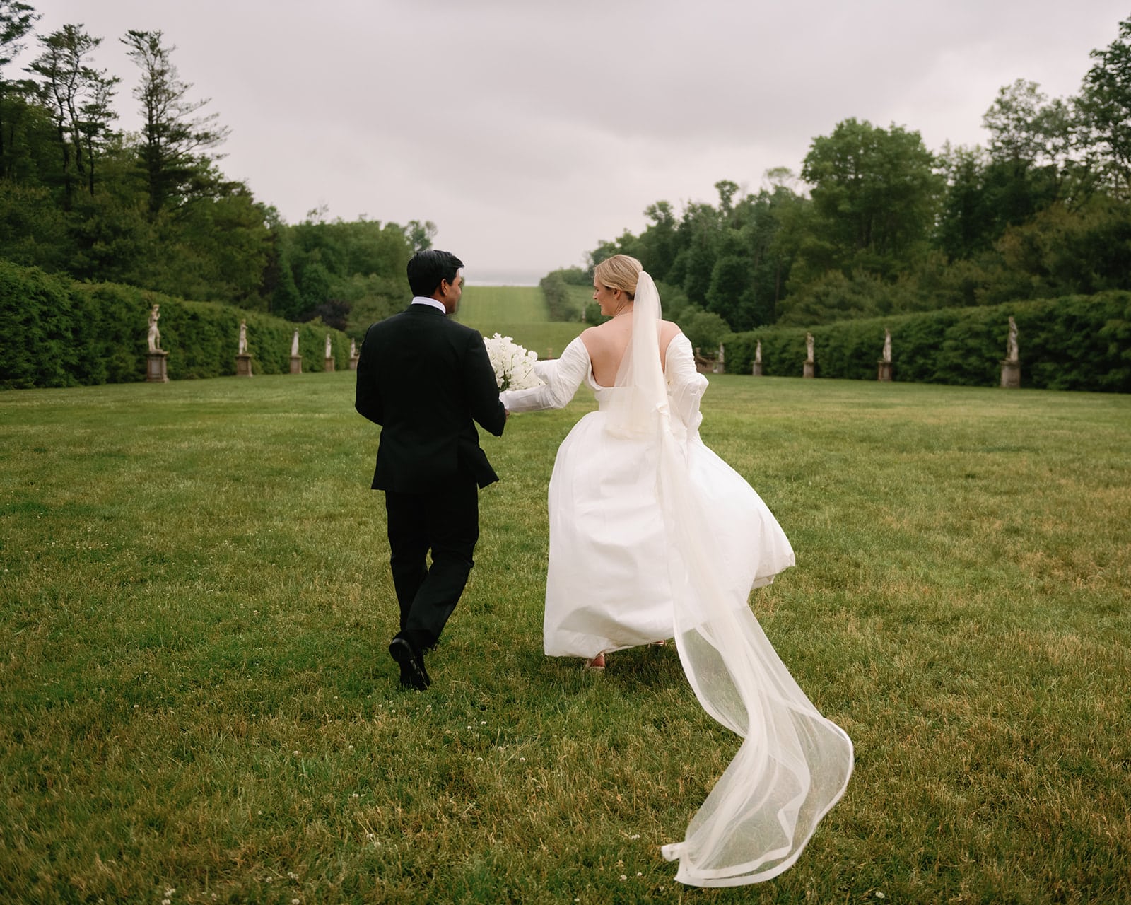 Bride and groom run together on the Grand Allée at The Crane Estate on the North Shore of Massachusetts.